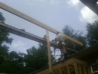 Carpenter setting a ridge beam over a new addition frame — Ice Dam Removal by Roofing Brothers in Harker Heights