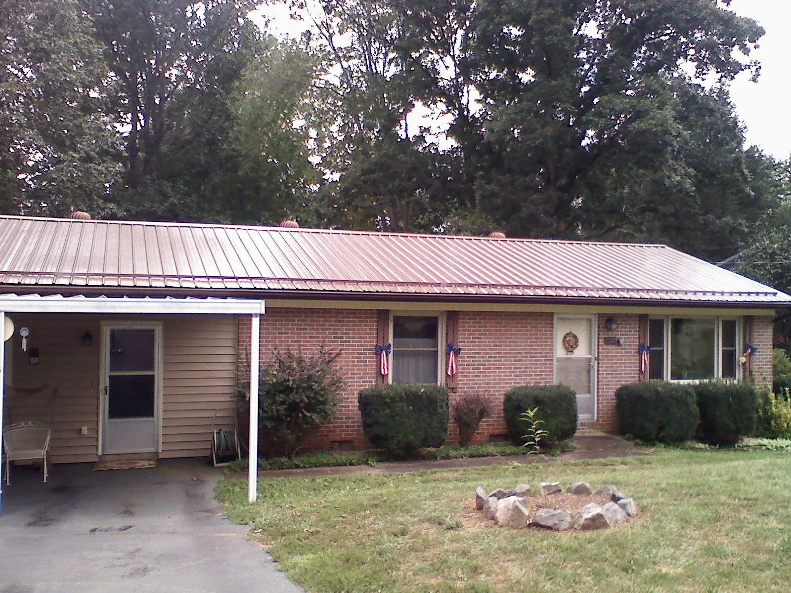 Bronze metal roof and carport on a brick ranch home — Roof Repair work by our crew in Harker Heights